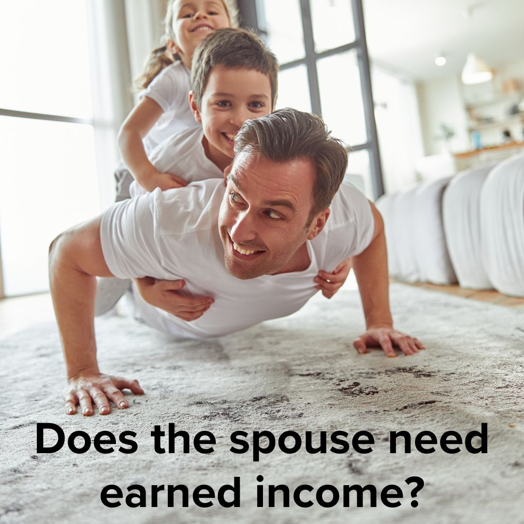 Man in a white shirt doing a pushup with a boy and girl on his back who are also wearing white shirts. They're on a carpeted floor in their home - likely a living room. Words in black font ask: 'Does the spouse need earned income?'
