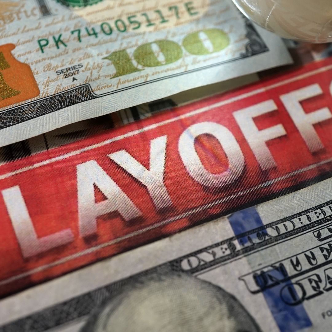 $100 bills with a large red and white 'LAYOFF' in the middle of the page.