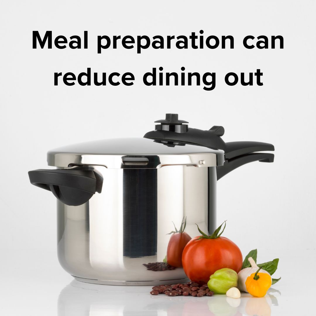 A pressure cooker with a fresh tomato, onion, and other vegetables next to it. Black text at the top says 'Meal preparation can reduce dining out' on a gray background.