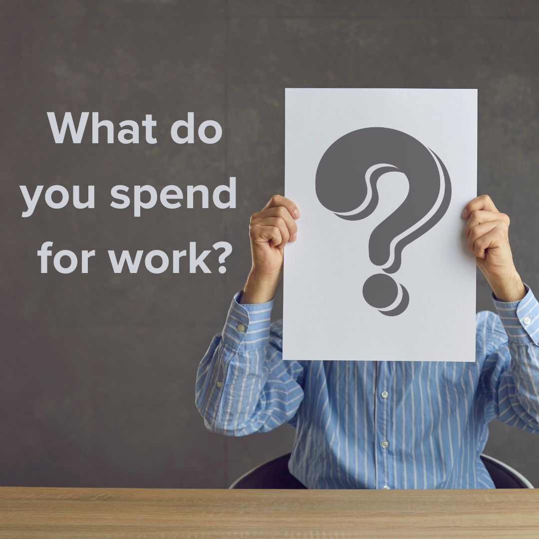 Title 'What do you spend for work?' in light text on the left. Photo of someone dressed in a button-up shirt sitting at a wooden desk with a large piece of paper and a gray question mark on it.