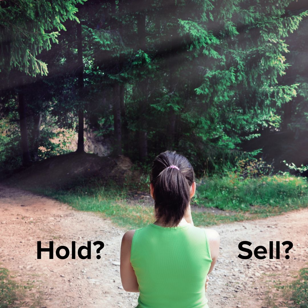 Photo of a woman deciding whether to take the path on the left or the right. The word 'Hold?' is on the left and 'Sell?' is on the right.